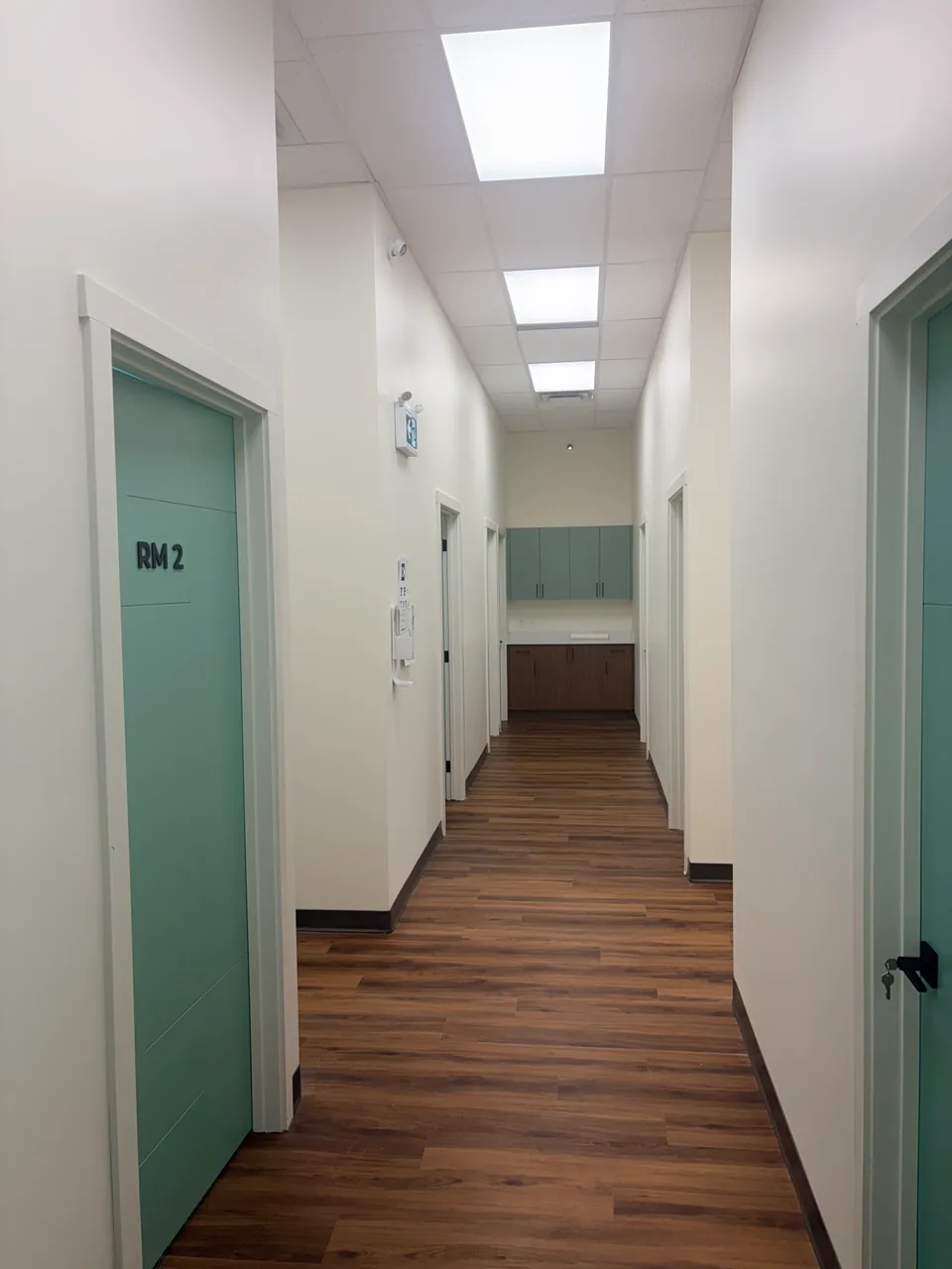 Madox Medical Clinic hallway with teal examination room doors